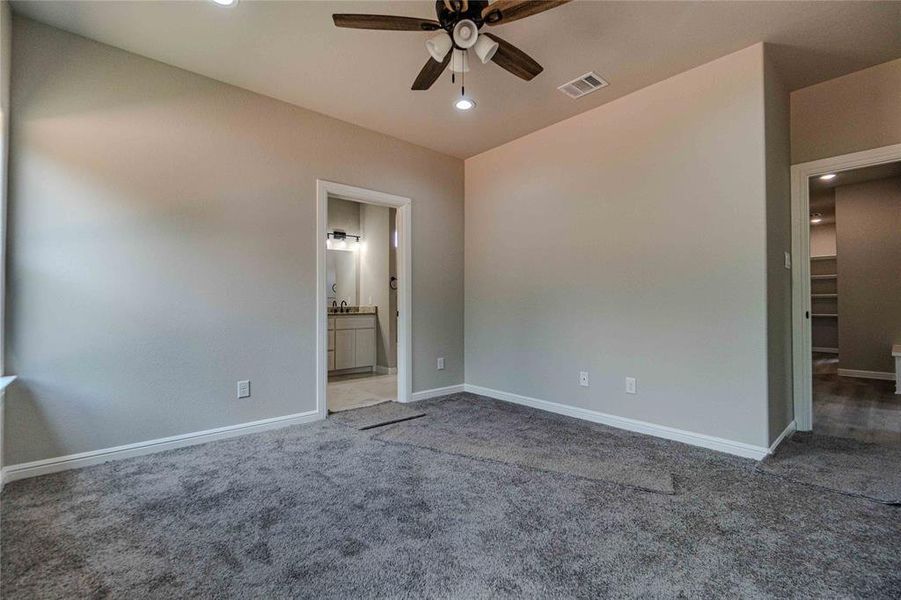 Unfurnished room featuring carpet floors and ceiling fan