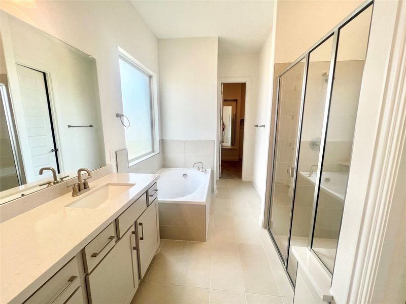 Bathroom with vanity, a stall shower, a garden tub, and tile patterned flooring Bathroom with vanity, a stall shower, a garden tub, and tile patterned flooring