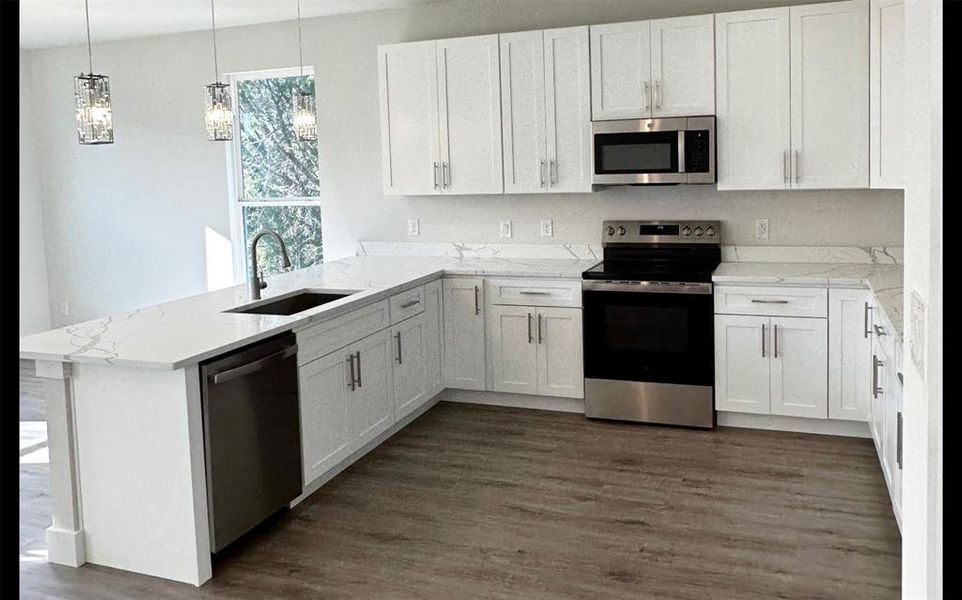 Kitchen with stainless steel package, white shaker cabinets, luxury vinly flooring