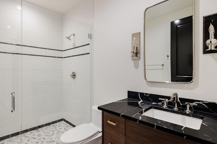 Striking contrast defines this ensuite bath, pairing rich black marble with warm wood tones and polished chrome fixtures for a sophisticated, gallery-inspired look. Striking contrast defines this ensuite bath, pairing rich black marble with warm wood tones and polished chrome fixtures for a sophisticated, gallery-inspired look.