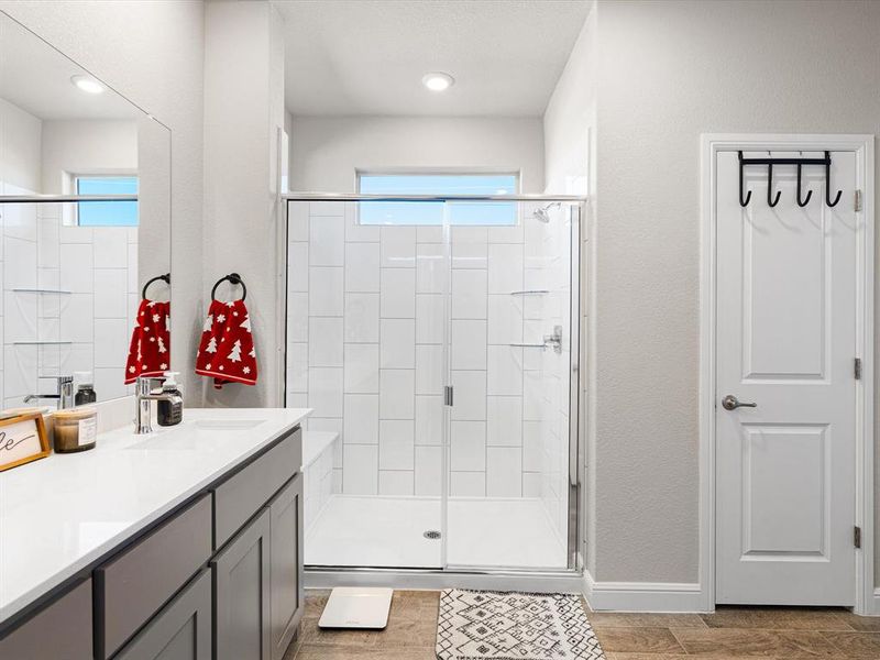 Bathroom featuring vanity, wood-type flooring, and an enclosed shower