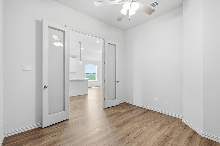 Empty room with ceiling fan and light wood-style flooring