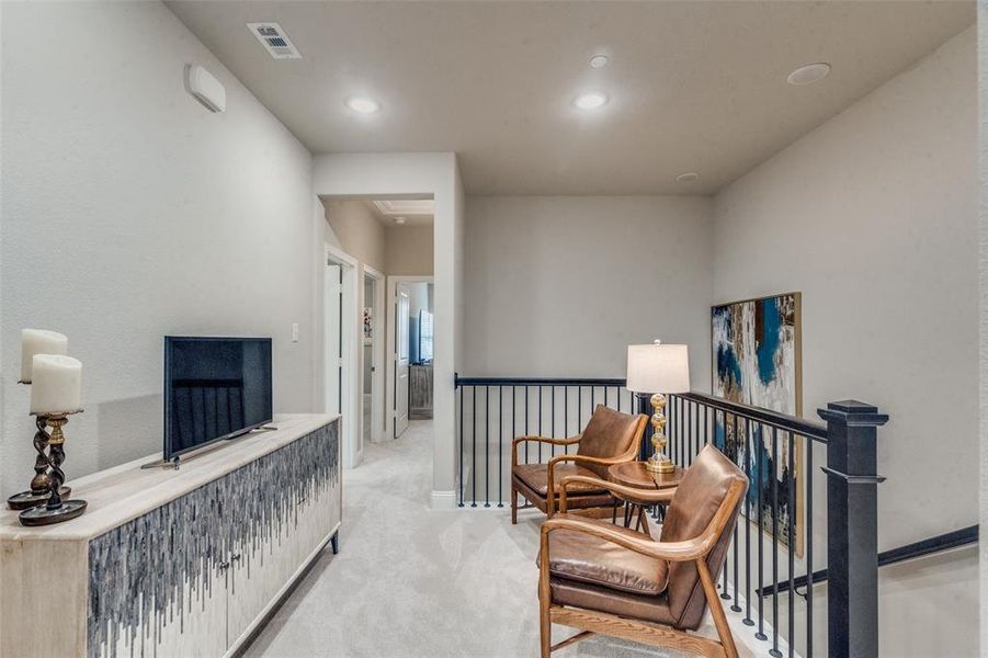 Hallway featuring light colored carpet