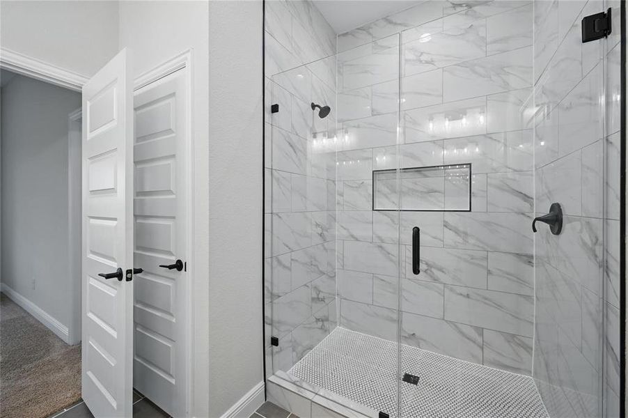 Full bath with a shower stall and baseboards Full bath with a shower stall and baseboards