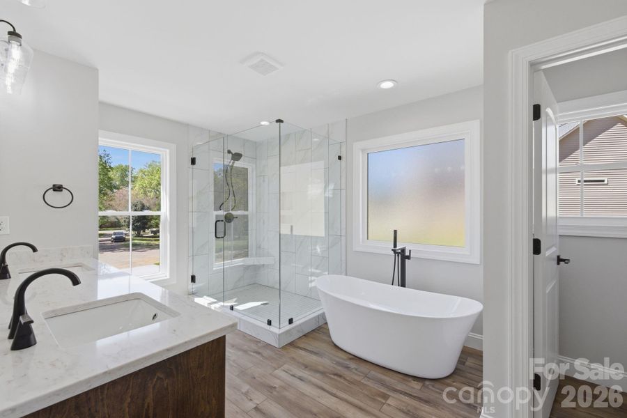 Large walk-in shower with tile extending to the ceiling alongside a garden soaking tub, creating a spa-like feel