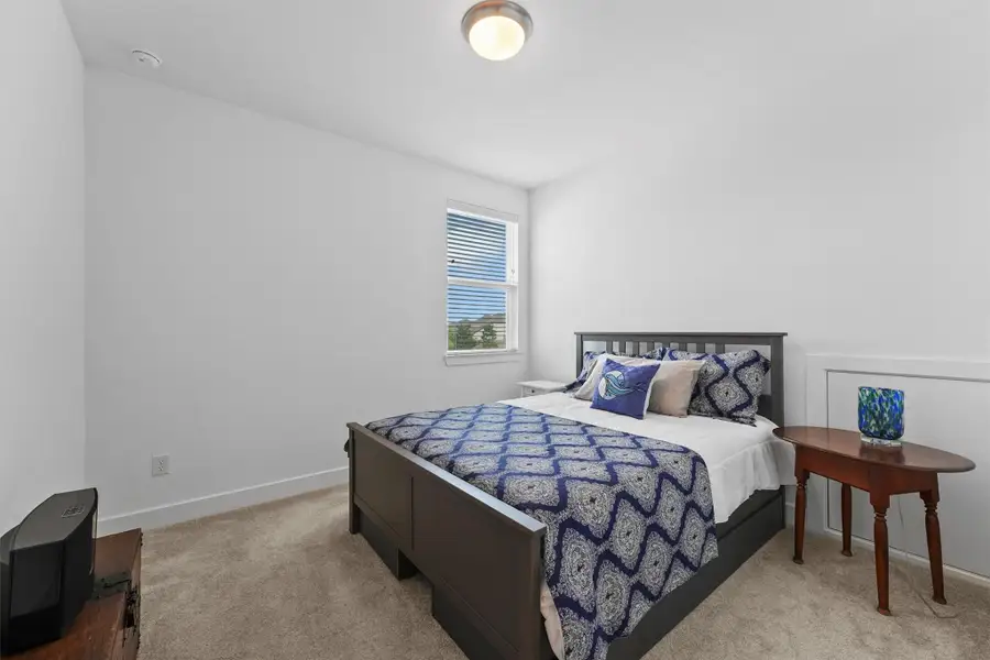 This bright and spacious secondary bedroom provides a comfortable and private space for family or guests. The large window allows for plenty of natural light, and the room offers a tranquil retreat.