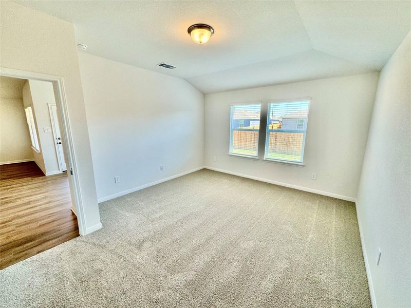 Spare room featuring light colored carpet, lofted ceiling, and a textured ceiling Spare room featuring light colored carpet, lofted ceiling, and a textured ceiling