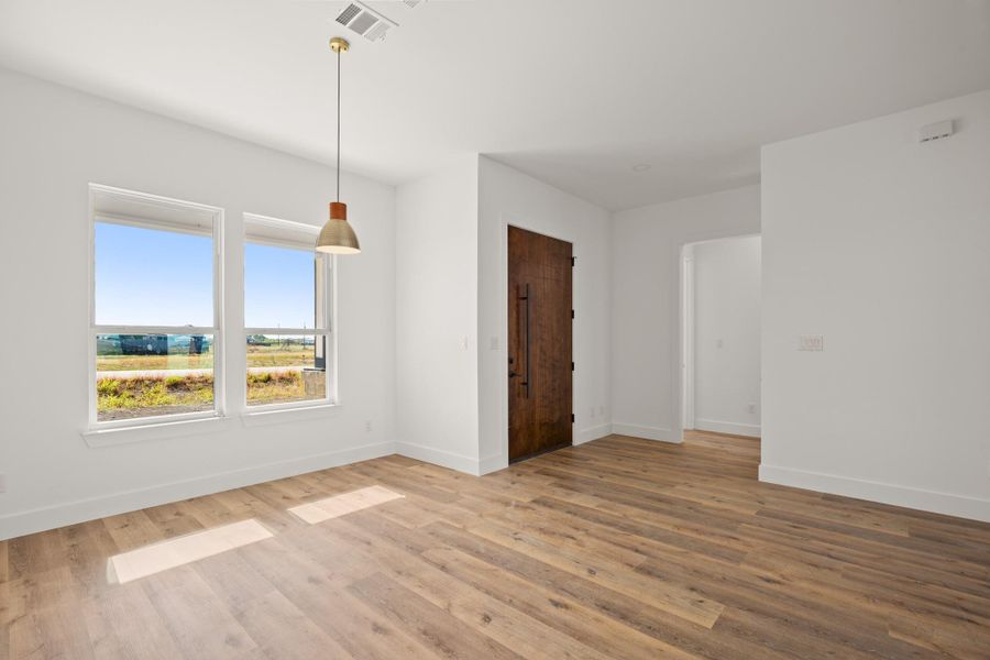 A warm wooden entry door and contemporary light fixture enhance this inviting room. A warm wooden entry door and contemporary light fixture enhance this inviting room.