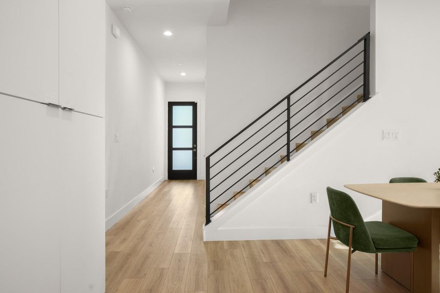 Modern wrought iron railings run up the partially opened staircase to the second floor game room and bedrooms. Modern wrought iron railings run up the partially opened staircase to the second floor game room and bedrooms.