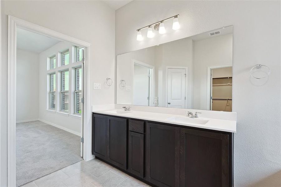 Bathroom featuring tile patterned floors and double sink vanity