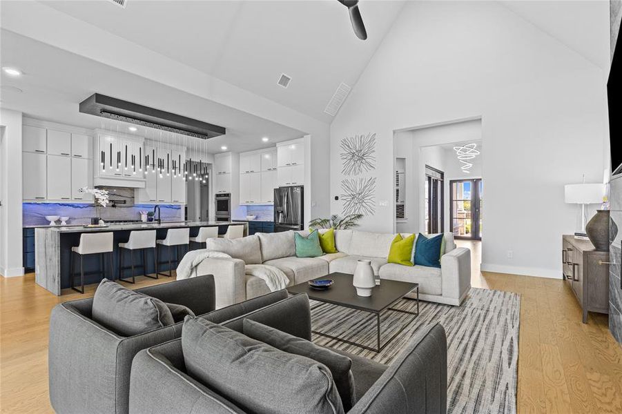 Living area featuring high vaulted ceiling and light wood-style flooring