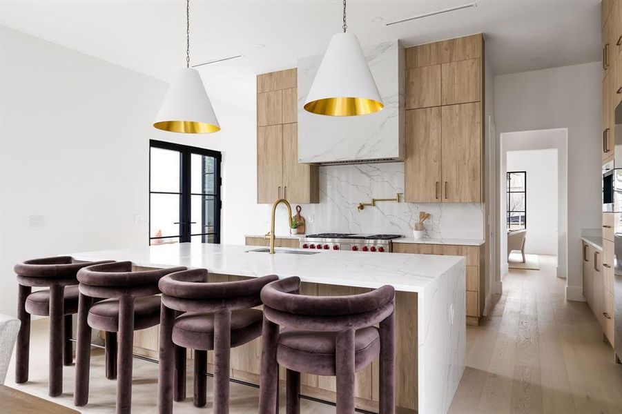 Kitchen with pendant lighting, a sink, a center island with sink, and modern cabinets