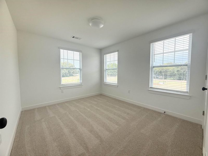Unfurnished room with baseboards and light colored carpet