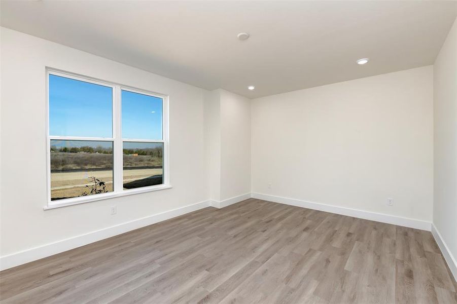 Spare room with baseboards, light wood-style flooring, and recessed lighting