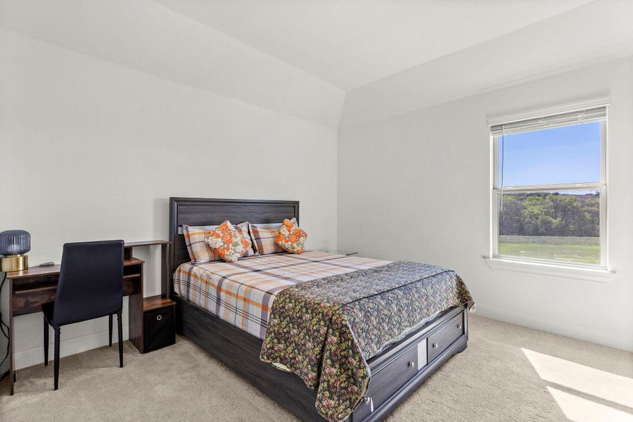 Bedroom featuring light carpet and an office area