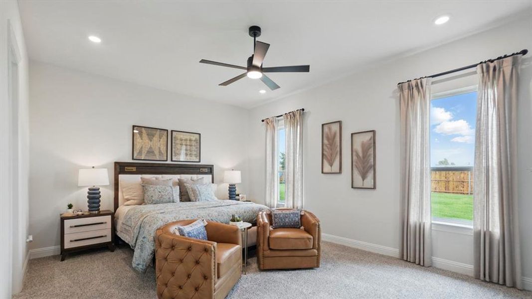 Spacious bedroom featuring light neutral walls, recessed lighting, and a dark-bladed ceiling fan
