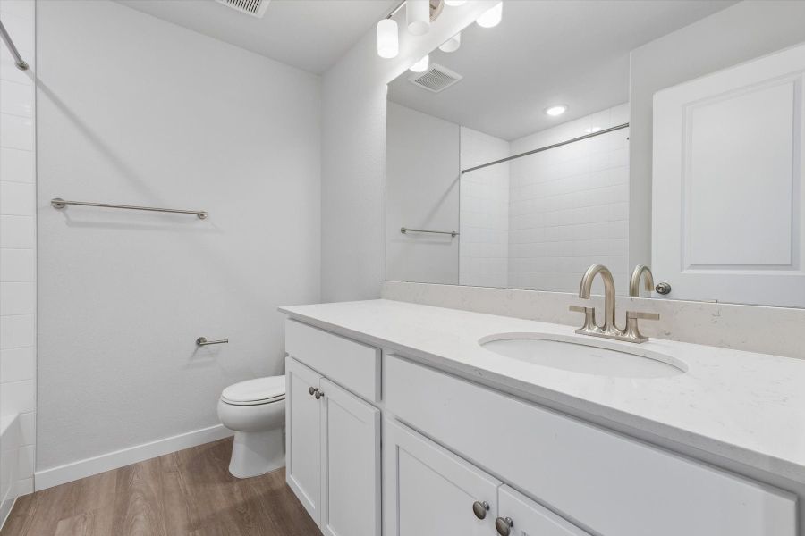 A bathroom with a sink toilet and mirror. A bathroom with a sink toilet and mirror.