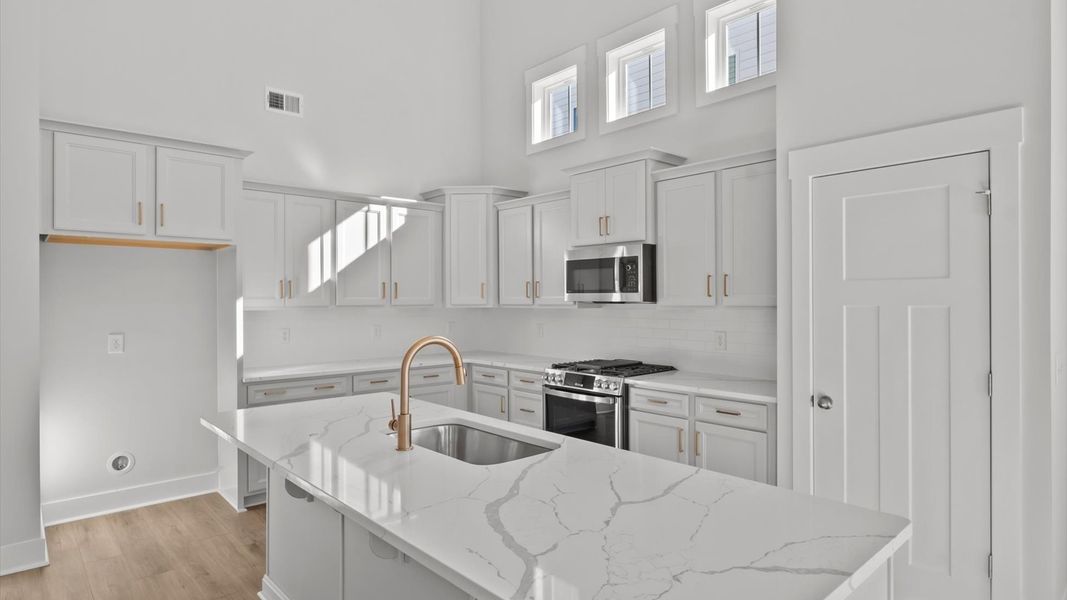 Elegant kitchen featuring a functional island and clean, current styling throughout