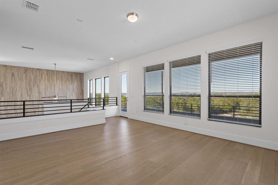 Spare room with light wood-type flooring and wood walls Spare room with light wood-type flooring and wood walls