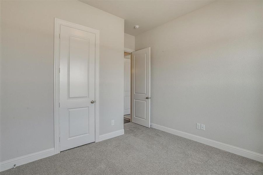 Unfurnished bedroom featuring light colored carpet