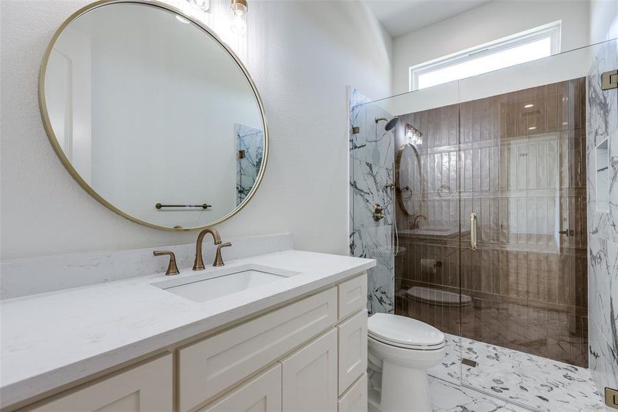 Bathroom with vanity, toilet, and an enclosed shower