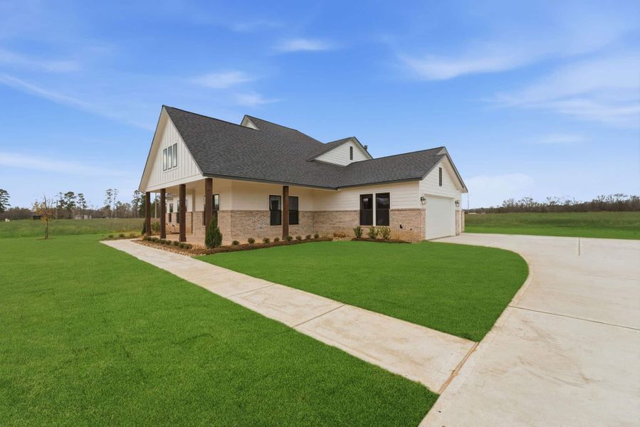 Front exterior of a new home in The Manors, New Waverly, TX, highlighting curb appeal (Image 24). Front exterior of a new home in The Manors, New Waverly, TX, highlighting curb appeal (Image 24).