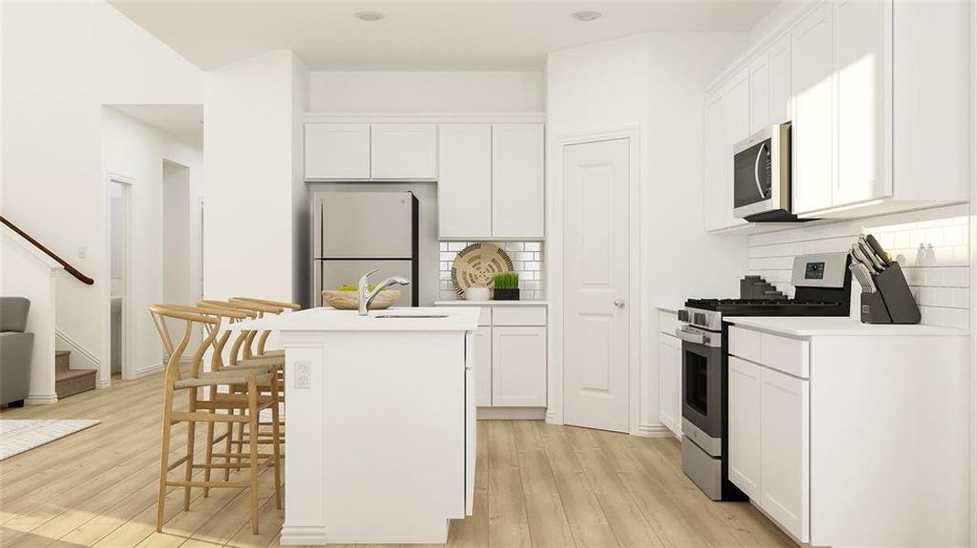 Kitchen featuring white cabinets, light wood-type flooring, appliances with stainless steel finishes, and a center island with sink