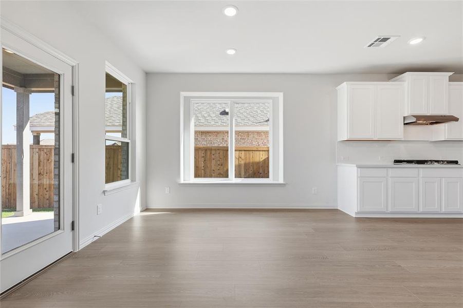 Unfurnished dining area with light wood-style floors, recessed lighting, and plenty of natural light Unfurnished dining area with light wood-style floors, recessed lighting, and plenty of natural light