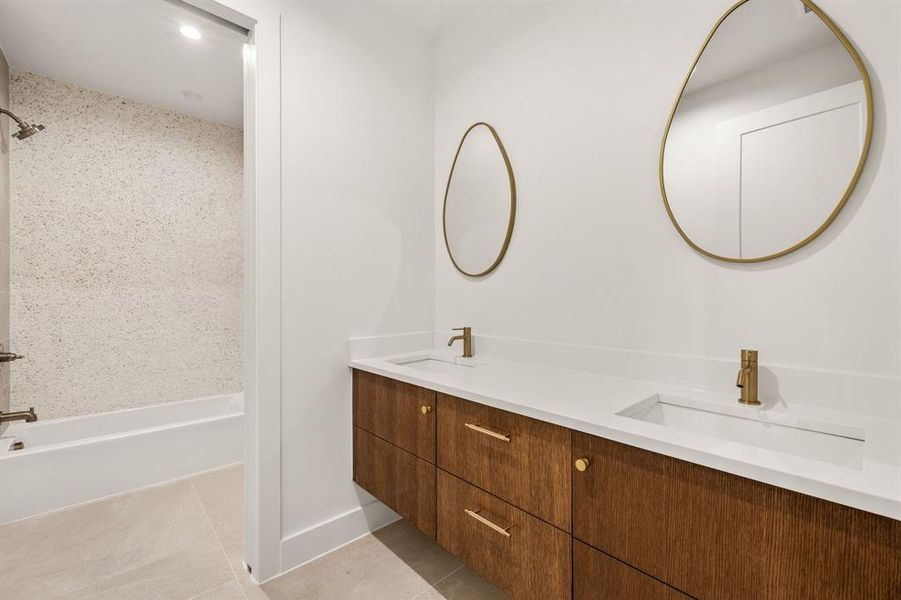 Bathroom with light tile patterned flooring, double vanity, and shower / tub combination Bathroom with light tile patterned flooring, double vanity, and shower / tub combination