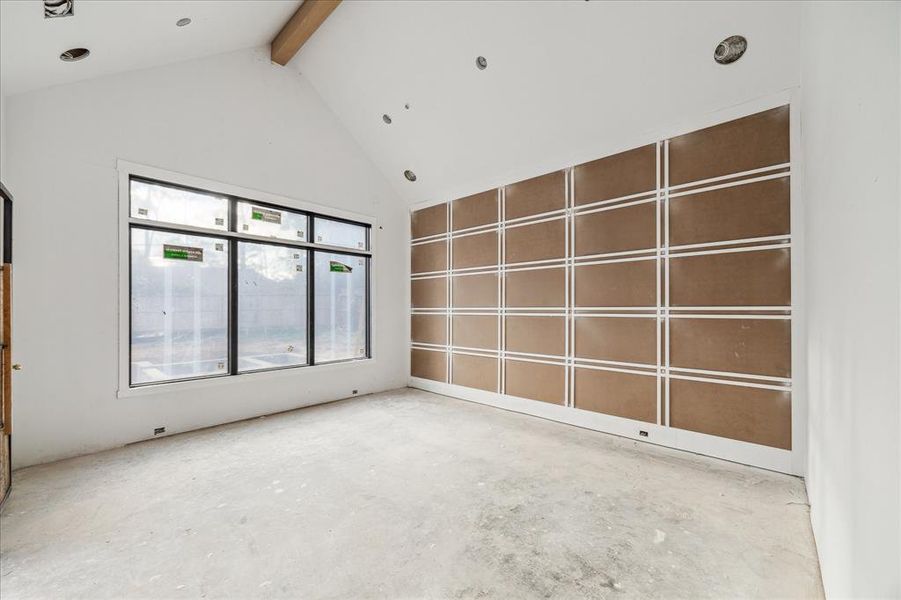 Primary bedroom with soaring vaulted ceiling and wall detail for a special design touch.