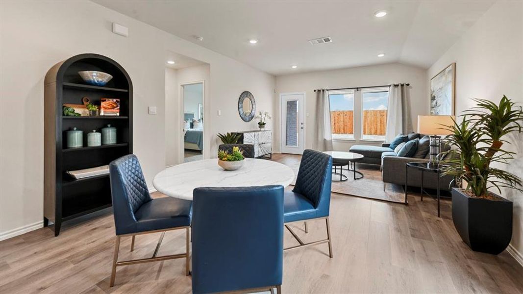 Dining room featuring recessed lighting, light wood-style floors, and lofted ceiling Dining room featuring recessed lighting, light wood-style floors, and lofted ceiling