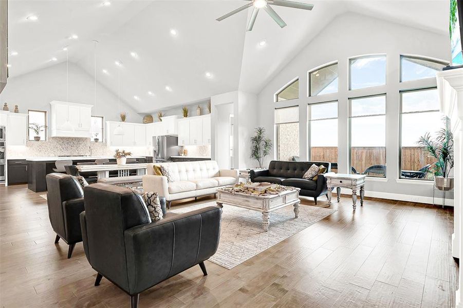 Living area featuring high vaulted ceiling, light wood-type flooring, ceiling fan, and recessed lighting