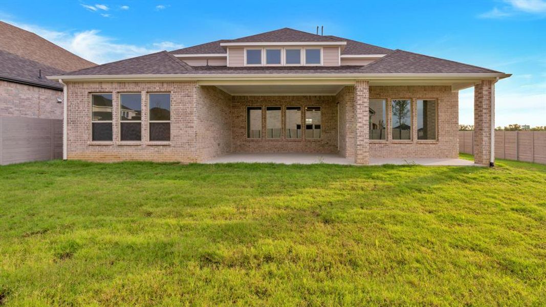 Rear view of house with a lawn and a patio area