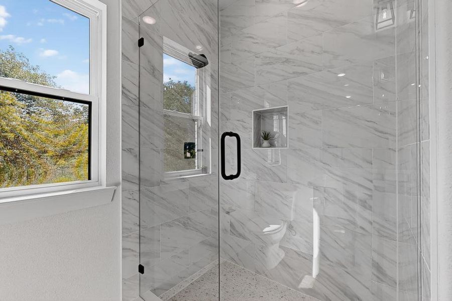 Full bathroom featuring a marble finish shower and toilet