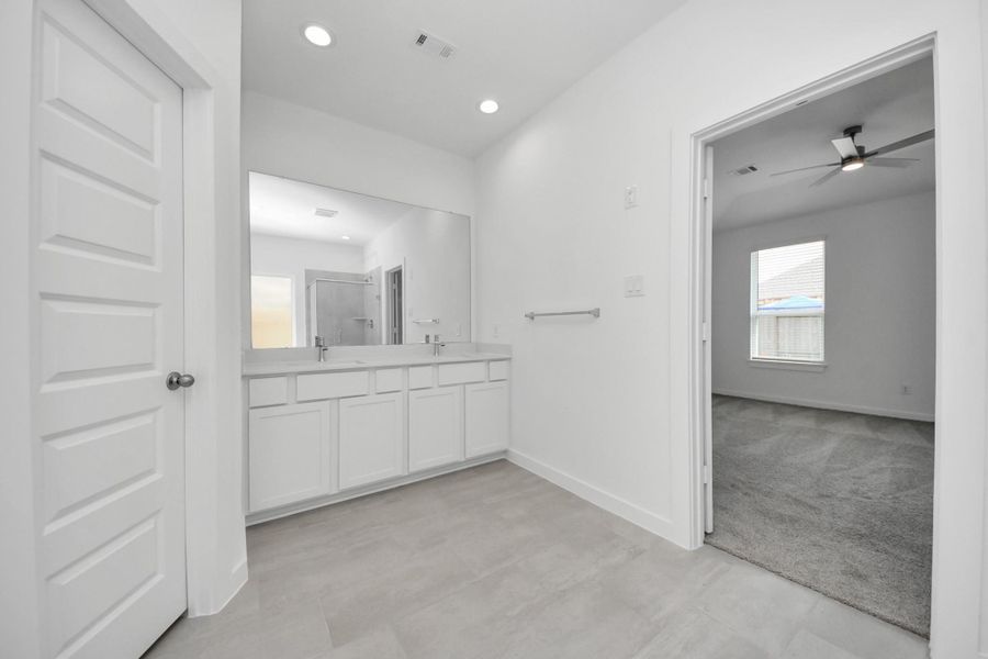Elevate your daily routine at the elegant vanity, now equipped with double sinks, light countertops, modern hardware, and beautiful recessed lights. Sample photo of completed home with similar floor plan. Actual colors and selections may vary. Elevate your daily routine at the elegant vanity, now equipped with double sinks, light countertops, modern hardware, and beautiful recessed lights. Sample photo of completed home with similar floor plan. Actual colors and selections may vary.