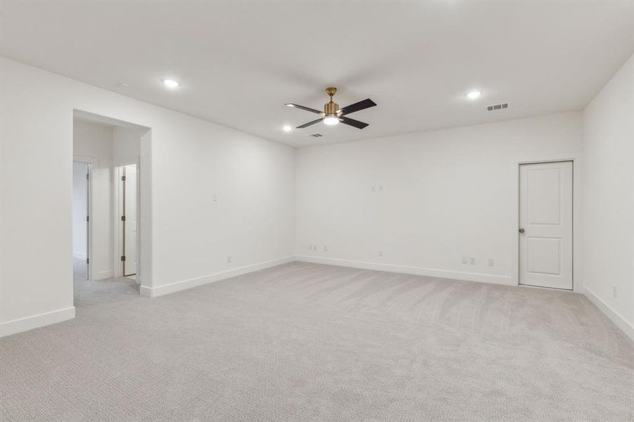 Unfurnished room with light colored carpet and ceiling fan