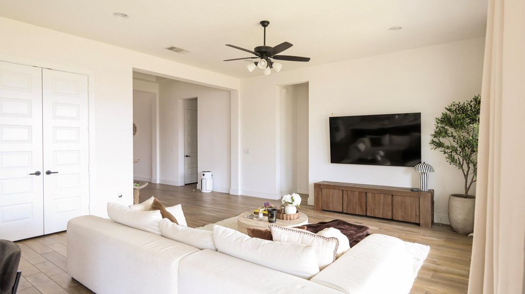 Recessed lighting and a ceiling fan illuminate this spacious, well-lit gathering space with hard surface flooring. Recessed lighting and a ceiling fan illuminate this spacious, well-lit gathering space with hard surface flooring.
