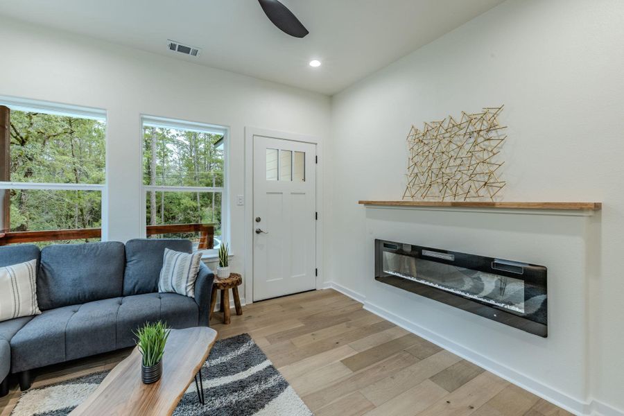 An inviting living area with rich hardwood flooring opens to a leafy outdoor view through generous windows. An inviting living area with rich hardwood flooring opens to a leafy outdoor view through generous windows.