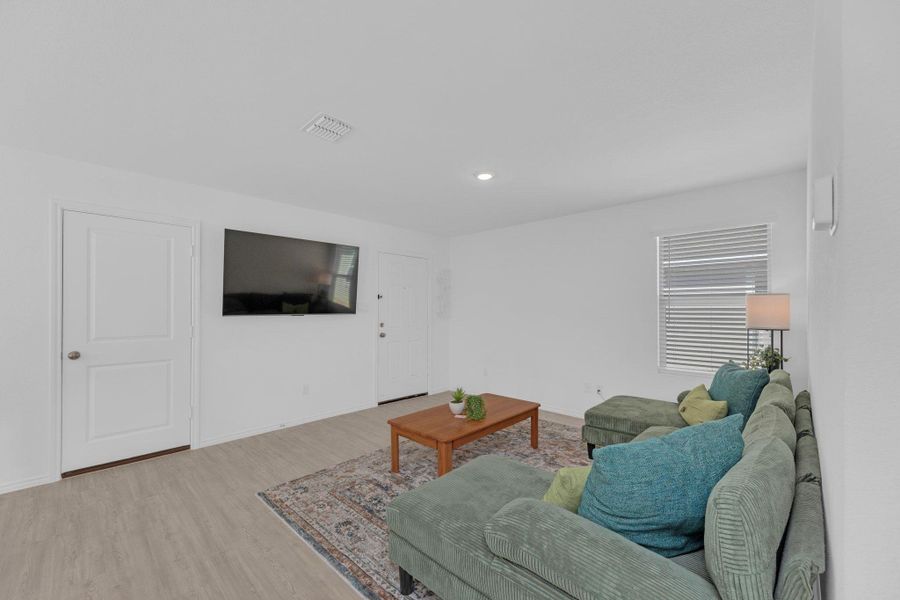 Bright open living room shows garage entrance.