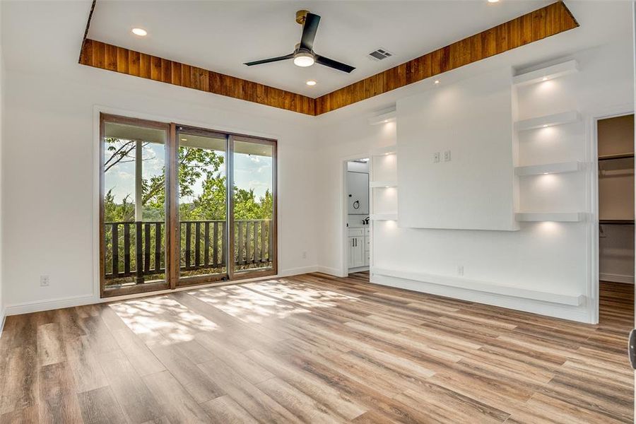 Empty room featuring light wood finished floors, a ceiling fan, recessed lighting, and a raised ceiling