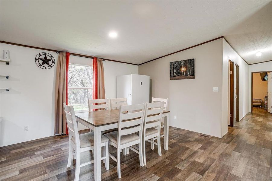 Dining room featuring dark wood-type flooring and ornamental molding