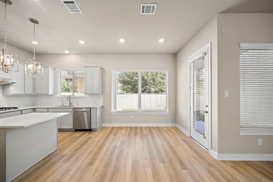 This modern, open-concept kitchen offers a seamless flow to the dining and living areas, perfect for both cooking and entertaining.