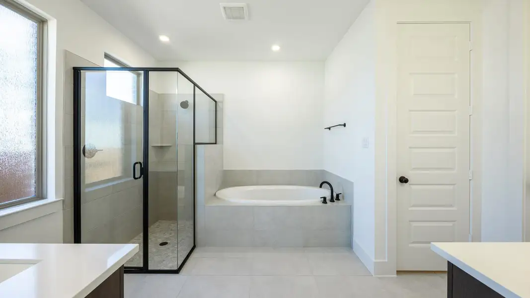 Full bath with a stall shower, a garden tub, vanity, and visible vents Full bath with a stall shower, a garden tub, vanity, and visible vents