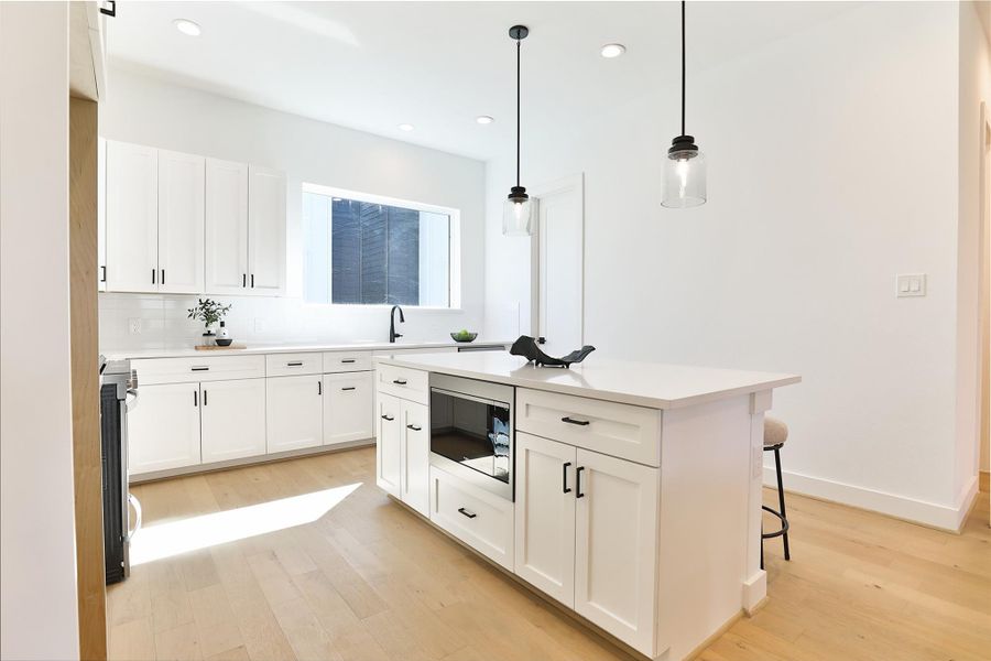 Contemporary fixtures and lighting, including the stylish Annabeth 8" Pendant. A spacious walk-in pantry tucked in the corner of this charming kitchen.