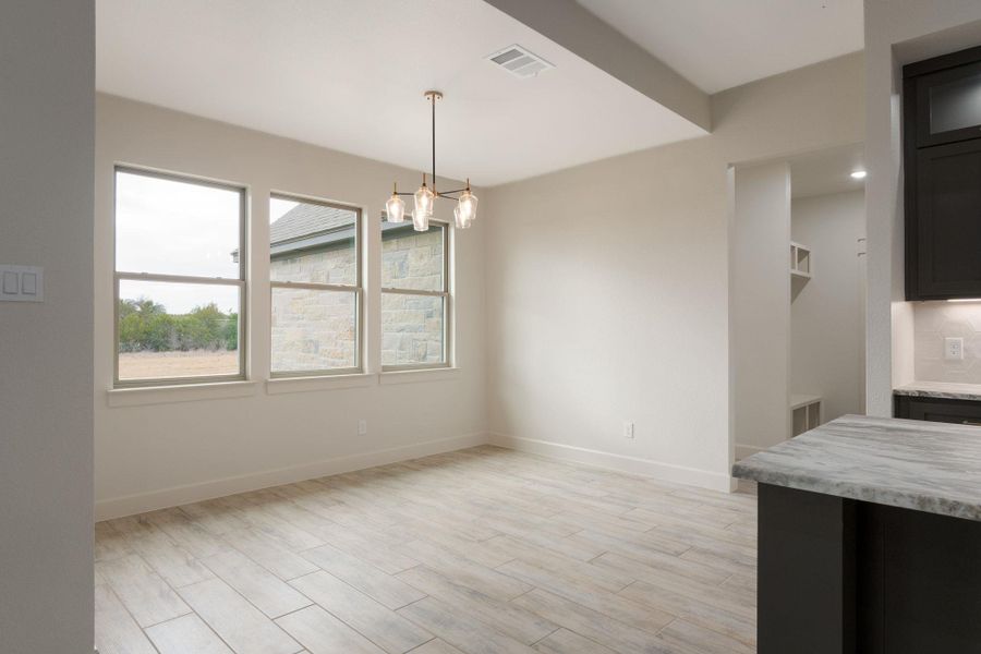 Unfurnished dining area featuring a chandelier and light wood finished floors