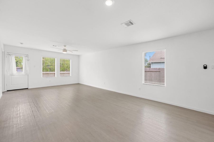 Multiple windows brighten the open living area, while the neutral color palette and continuous flooring create a clean, cohesive look. Multiple windows brighten the open living area, while the neutral color palette and continuous flooring create a clean, cohesive look.