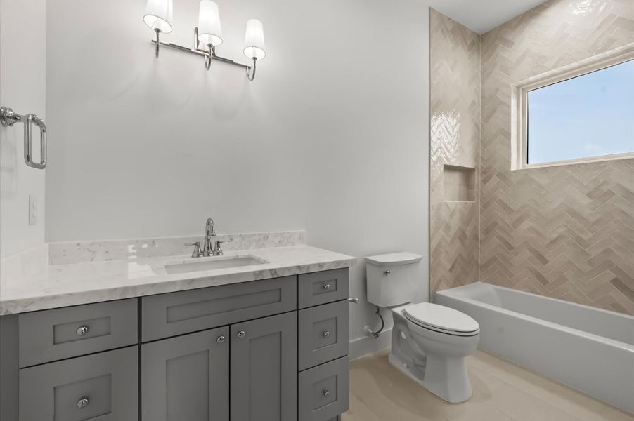 Secondary bathroom featuring quality cabinetry, generous counter space, and elegant fixtures. Secondary bathroom featuring quality cabinetry, generous counter space, and elegant fixtures.