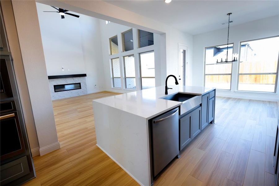 Kitchen with pendant lighting, light wood-style flooring, open floor plan, light stone countertops, and recessed lighting Kitchen with pendant lighting, light wood-style flooring, open floor plan, light stone countertops, and recessed lighting