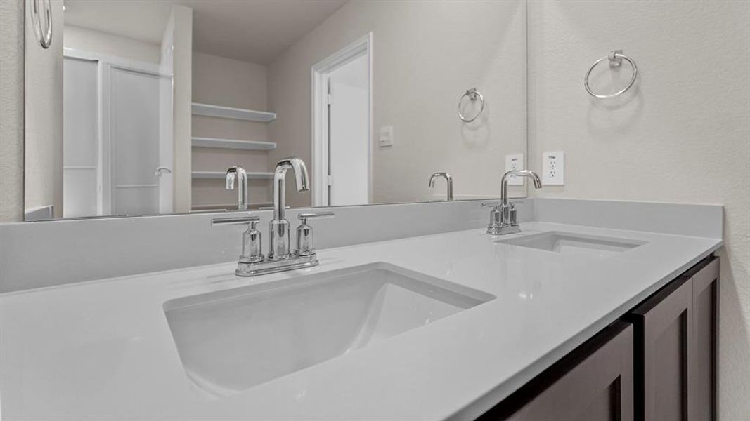 Dual undermount sinks with chrome fixtures set into a light-toned countertop