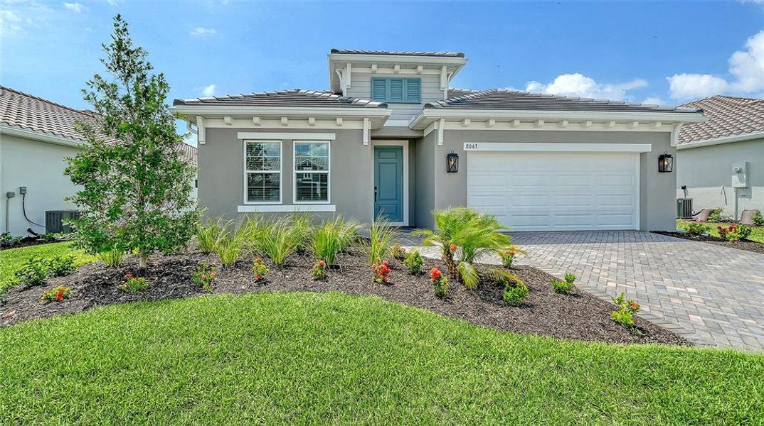 Front exterior of a new home in Windward, Lakewood Ranch, FL, highlighting curb appeal (Image 1). Front exterior of a new home in Windward, Lakewood Ranch, FL, highlighting curb appeal (Image 1).